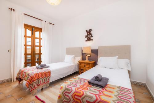 a bedroom with two beds and a table with a lamp at Sa Fonteta Cala Morlanda in S'Illot