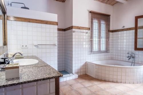 a bathroom with a tub and a sink at Can Moustique in Sant Josep de sa Talaia