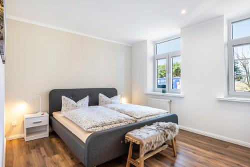 a bedroom with a bed and two windows at Ferienwohnung Alte Schule in Wester-Bargum