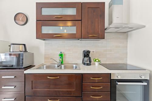 a kitchen with wooden cabinets and a sink at Casa Rocca in Bosa