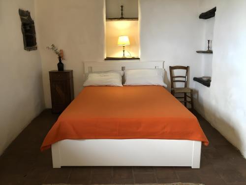 a bedroom with a bed with an orange blanket at Lovers' Nest - Unità 1 in Baiardo