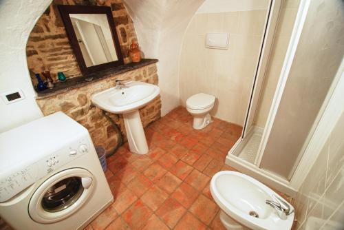 a bathroom with a toilet sink and a washing machine at Lovers' Nest - Unità 1 in Baiardo