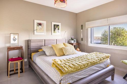a bedroom with a bed with yellow pillows and a window at Un Thé sur la Loire in Ballan-Miré