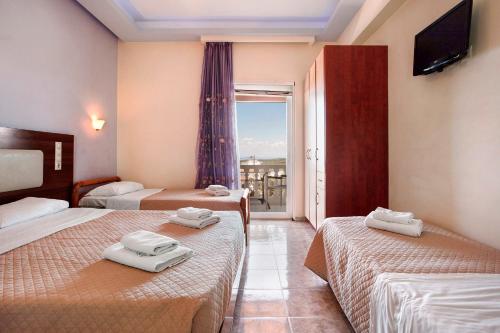 a hotel room with two beds and a balcony at Zante View Family Studio 2 in Tsilivi