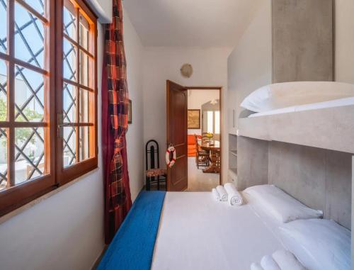 a bedroom with two bunk beds and a window at Villa del Mirto Punta Prosciutto in Torre Lapillo
