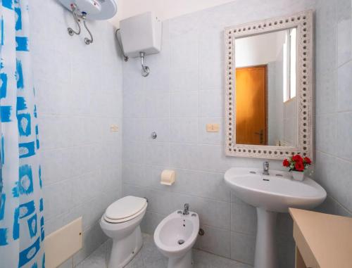 a bathroom with a toilet and a sink and a mirror at Villa del Mirto Punta Prosciutto in Torre Lapillo