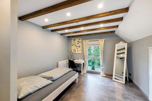 a bedroom with a bed and a desk and a window at Modernes Loft mitten im Grünen in Neukirchen-Vluyn