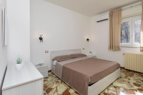 a bedroom with a bed in a white room at Sentiti A Casa - Bronte in Bronte