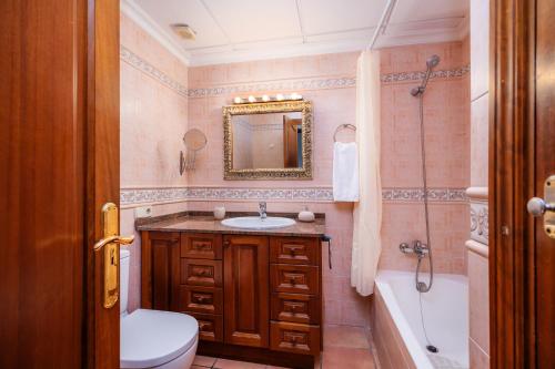 a bathroom with a sink and a toilet and a tub at Dofí in Cala Millor