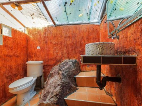 a bathroom with a toilet and a sink and a rock at Phuphaya Seaview Adults Only in Phi Phi Islands