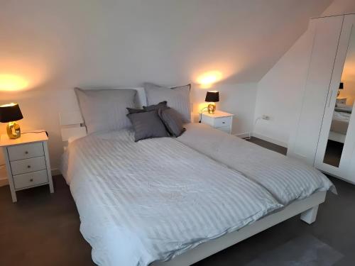 a bedroom with a white bed with two night stands at Ferienhaus Timeout in Friedrichskoog