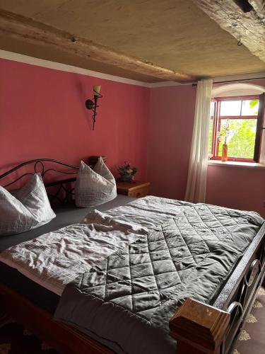 a bed in a bedroom with a red wall at Ferienwohnung Blaue Maus in Meißen