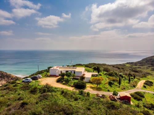 a house on a hill next to the ocean at Casa das Furnas - Eco Home in Vila do Bispo
