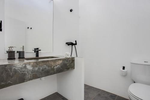 a bathroom with a sink and a toilet at Casa das Furnas - Eco Home in Vila do Bispo