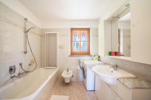a bathroom with a sink and a tub and a toilet at Hoferhof Apartement Bergspitze in Schenna