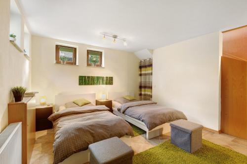 a bedroom with two beds and a room with two chairs at Ferienwohnung Quinkert in Eslohe