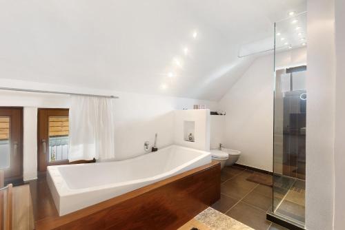 a bathroom with a bath tub and a toilet at Ferienwohnung Quinkert in Eslohe