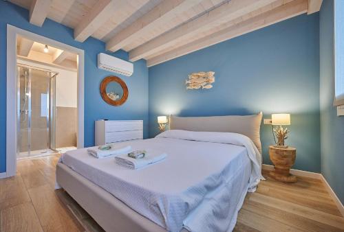 a blue bedroom with a bed with two towels on it at Ca' Marano Apartments in Centro