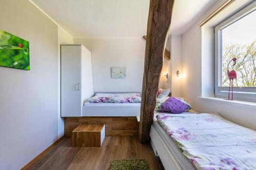 a room with two beds and a window at Haevn-Erholung, Fewo Deichblick in Reußenköge