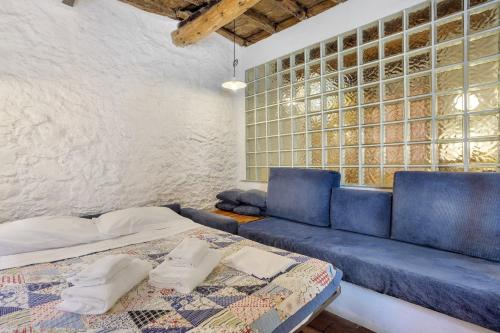 a living room with a blue couch and a window at Casa Nemo - Riomaggiore, 5 Terre in Riomaggiore