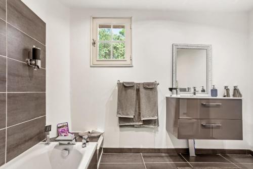 a white bathroom with a tub and a sink at Bastide Lou Pèbre D’aï in La Roquebrussanne