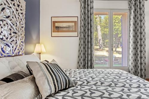 a bedroom with a bed and a window at Bastide Lou Pèbre D’aï in La Roquebrussanne