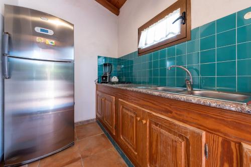a kitchen with a stainless steel refrigerator and a sink at Villa Gle in Quartu SantʼElena