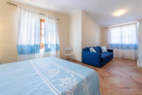 a bedroom with a blue bed and a blue couch at Villa Gle in Quartu SantʼElena