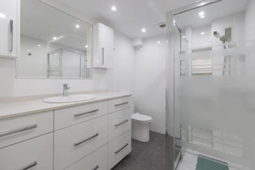 a white bathroom with a sink and a shower at Penthouse with private pool in Málaga