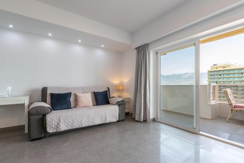 a living room with a couch and a large window at Penthouse with private pool in Málaga