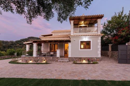 a house with a patio in front of it at Villa Logas Hill in Peroulades
