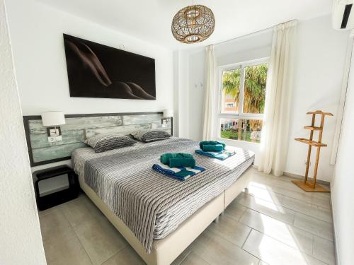 a bedroom with a bed with towels on it at Front Americano in Torrox Costa