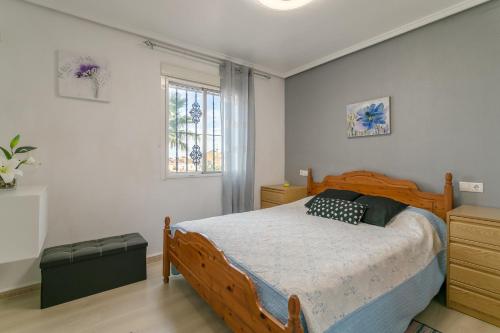 a bedroom with a wooden bed and a window at Rr Villa in Monforte del Cid