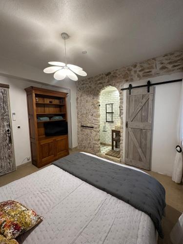 a bedroom with a large bed and a barn door at Le Saint Marquan in Brantes