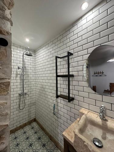 a white bathroom with a sink and a shower at Le Saint Marquan in Brantes