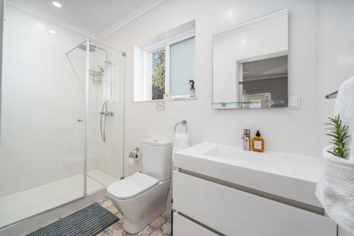 a white bathroom with a toilet and a sink at Orange Blossom Grove in São Bartolomeu de Messines