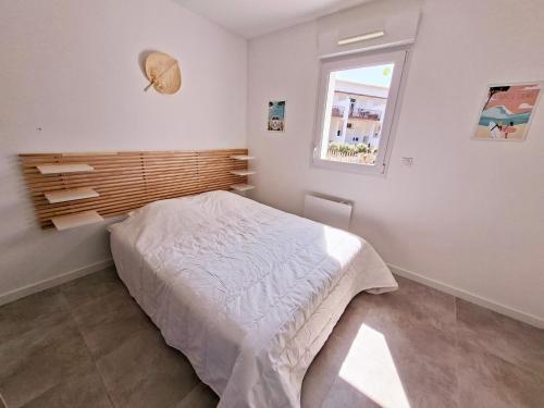 a bedroom with a bed and a window at La maison de Fabien - Piscine in La Tranche-sur-Mer