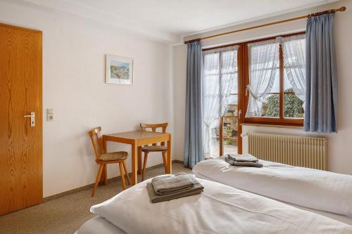 a bedroom with two beds and a table and a window at Ferienhaus Schwörer in Feldberg