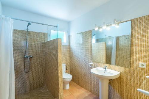 a bathroom with a shower and a toilet and a sink at Villa Mariola in Sant Lluis