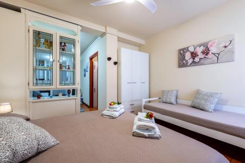 a bedroom with a bed and a couch and a window at Casa Jessika in Gardone Riviera