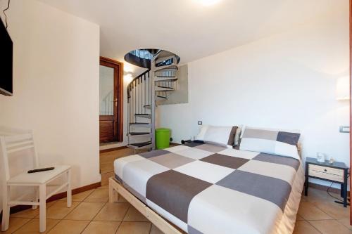 a bedroom with a large bed and a spiral staircase at Crotto Palma in Dongo