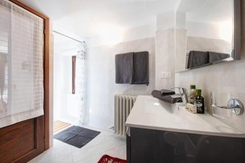 a white kitchen with a sink and a shower at Crotto Palma in Dongo