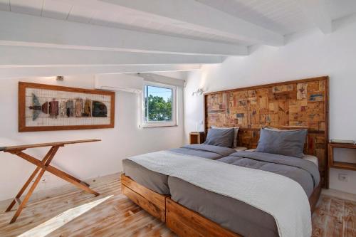 a bedroom with two beds and a table at Estúdio Casa Do Limoeiro in Nora