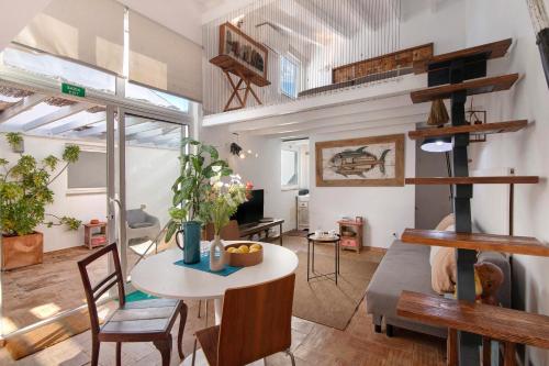 a room with a table and chairs and a loft at Estúdio Casa Do Limoeiro in Nora