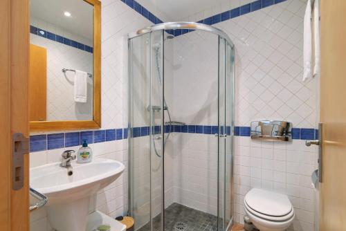 a bathroom with a shower and a toilet and a sink at Apartamento Tavirasol in Tavira