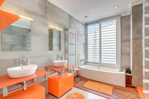 a bathroom with two sinks and a bath tub and a tubermott at Villa Ronda Estación in Porreres