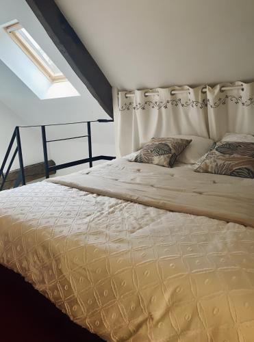 a large bed in a room with a window at Gîte De La Ferme Du Tilleul in La Pellerine