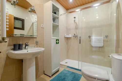 a bathroom with a toilet sink and a shower at Casa Mourelo Alojamento Local in Ponte da Barca