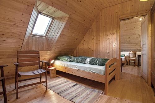 a bedroom in a log cabin with a bed and a chair at Ferienwohnung Alte Bauernkate in Süderholz