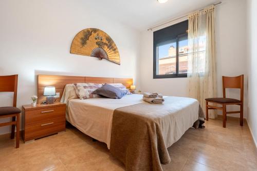 a bedroom with a bed and two chairs and a window at Ca la Mercè in Camarles